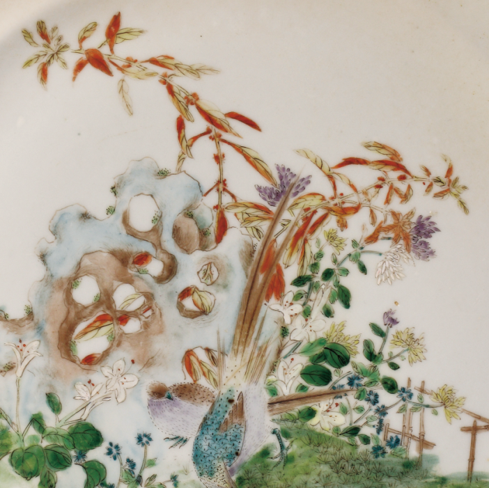 圖為1909年廣彩“廣東博物商會(huì)”石景紋碟細(xì)節(jié)圖，此碟將傳統(tǒng)國(guó)畫藝術(shù)與廣彩瓷技藝結(jié)合在一起，來(lái)表現(xiàn)優(yōu)美的石景風(fēng)光，畫面清新簡(jiǎn)潔。廣東博物商會(huì)由高劍父、陳樹人等人于1908 年在廣州市珠江南保安社八號(hào)以股份形式創(chuàng)辦，高劍父擔(dān)任會(huì)長(zhǎng)。畫師們以墨彩、綠彩、黃彩、大紅為主，運(yùn)用嶺南畫派繪畫技法，區(qū)別于傳統(tǒng)廣州彩瓷。（來(lái)源：廣州十三行博物館）