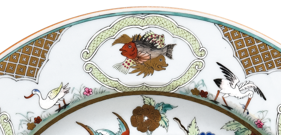 圖為清中期廣彩人物紋大碟細(xì)節(jié)圖，碟沿對稱開六窗繪魚紋，間繪六組鳥禽紋。（來源：廣州十三行博物館）