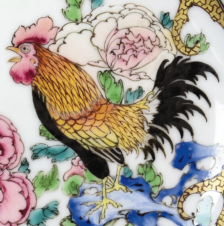 圖為清雍正廣彩“白云山人”碟細(xì)節(jié)圖，碟心繪一只高昂雄雞立于一太湖石上，雞冠高聳，引吭高鳴。（來(lái)源：廣州十三行博物館）