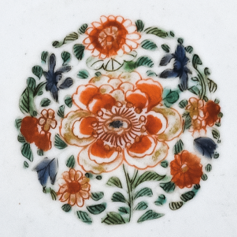 圖為清代五彩花卉紋碟細(xì)節(jié)圖，碟心主題紋飾為團(tuán)花圖，紅花綠葉，相映成趣。（來源：廣州十三行博物館）