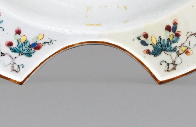 圖為清中期粉彩花卉紋剃須盤細節(jié)圖，該盤是男士剃胡須時使用的，弧形缺口能夠卡住下巴，刮起胡須來更方便。（來源：廣州十三行博物館）